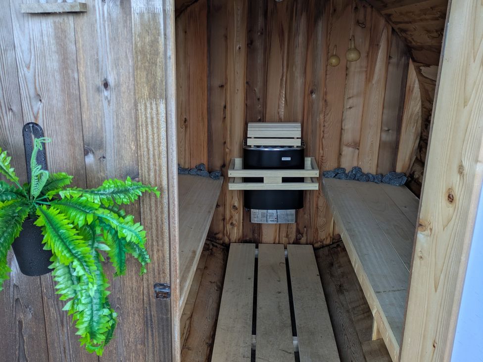A sauna with wooden walls and a stool inside at Faodail Studio Kingsburgh near Uig
