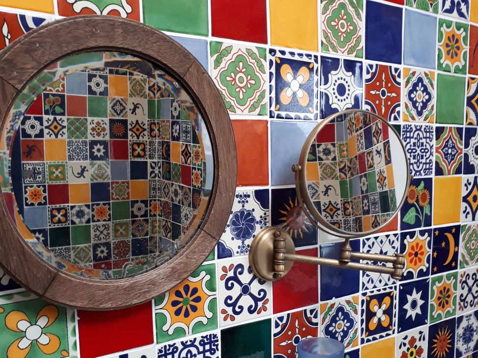 Two mirrors positioned against a colorful tiled wall at Taigh Phinc, Balemore near Lochmaddy, North Uist