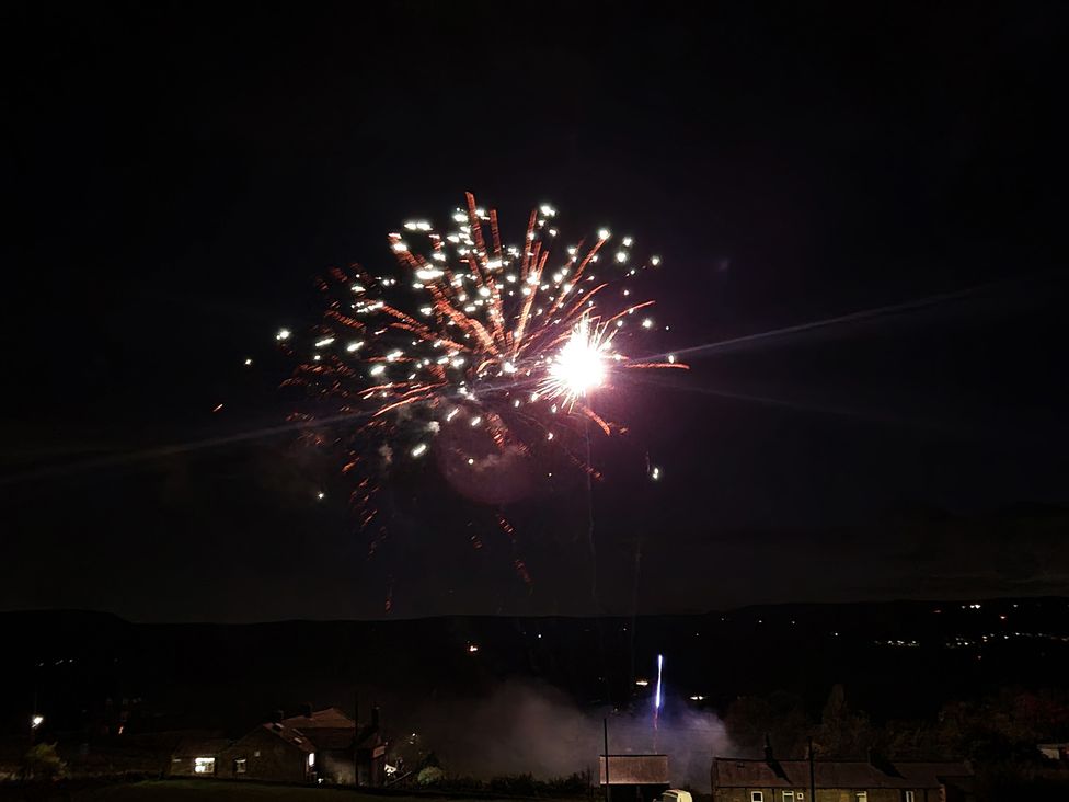 Fireworks display in the sky near houses at Popples Barn near Hebden Bridge