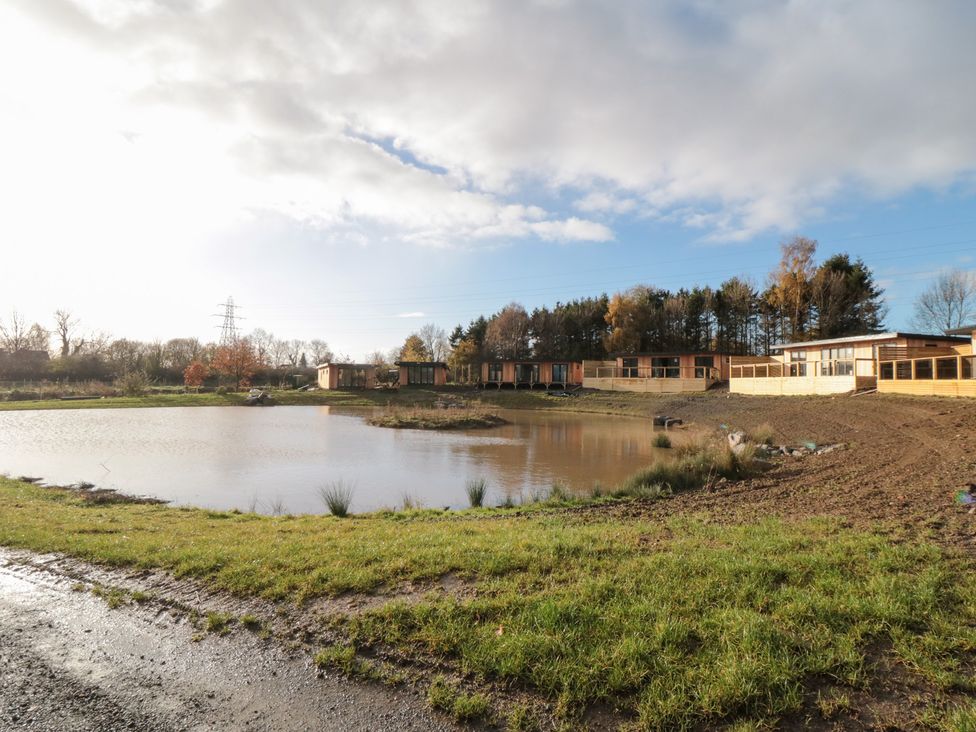 A pond with buildings and trees in the background at Lodge 6 Stockton-on-Tees