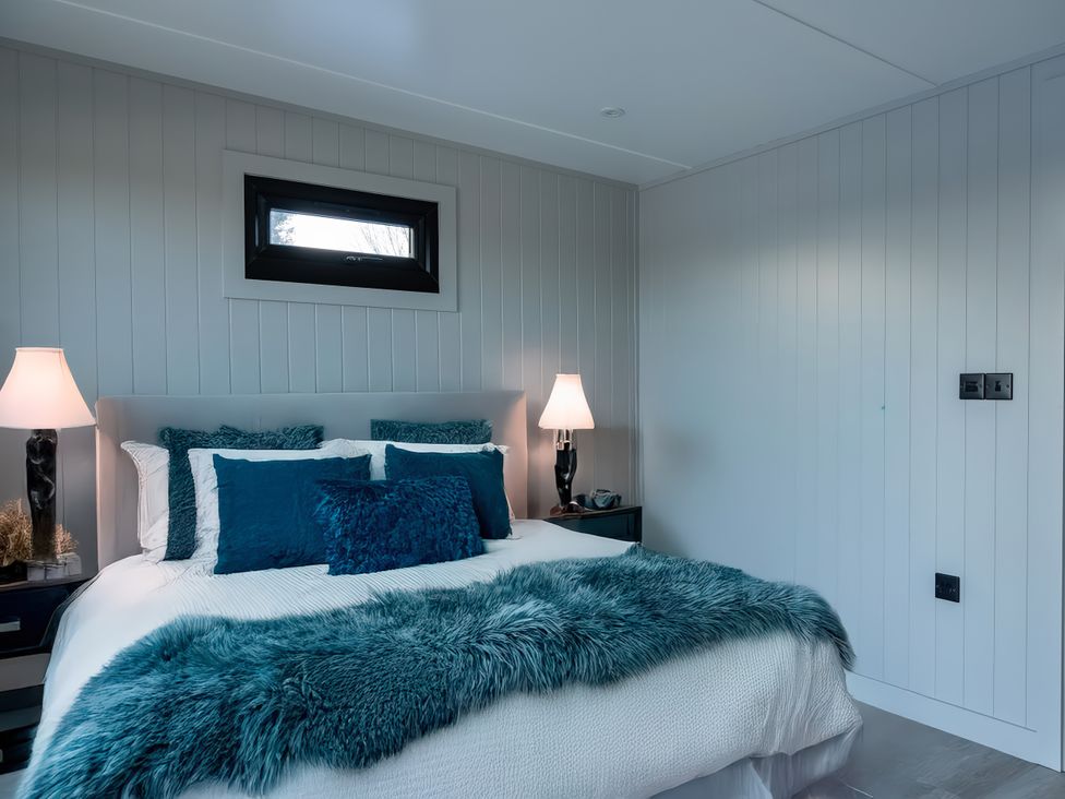 A bedroom with a bed and lamps at Lovebird Lodge in Yarm