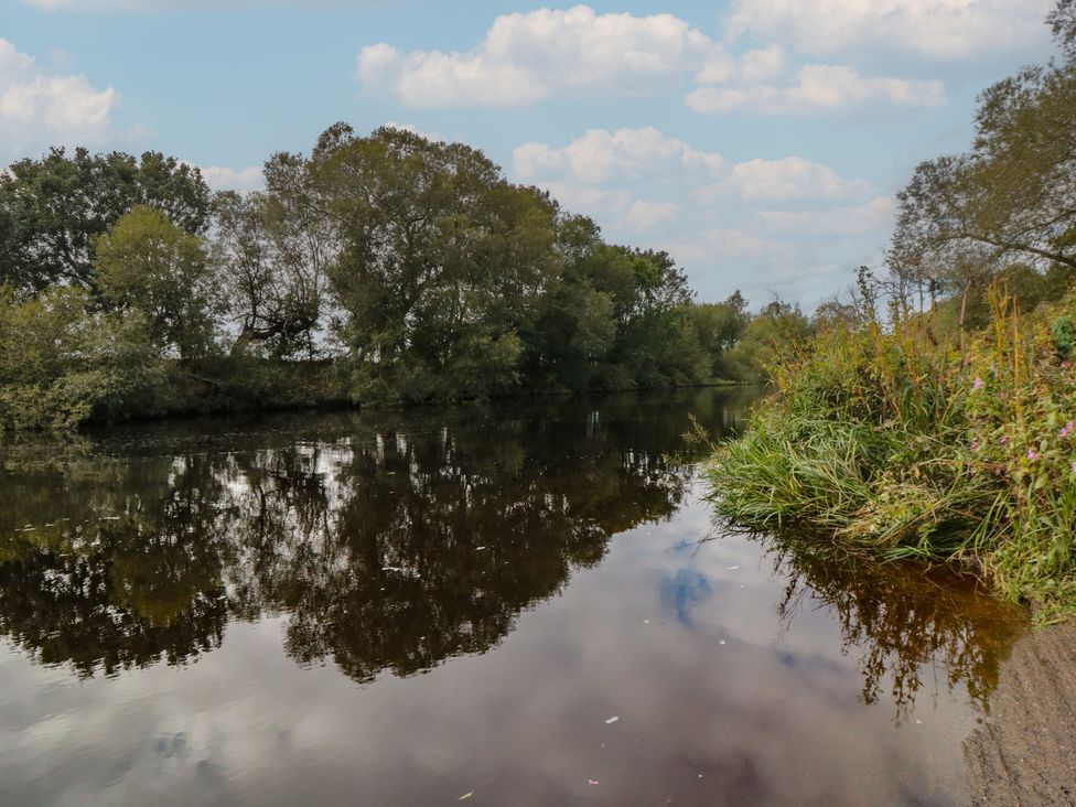 A river bordered by trees and grass with reflections at Lodge 8 Stockton-on-Tees