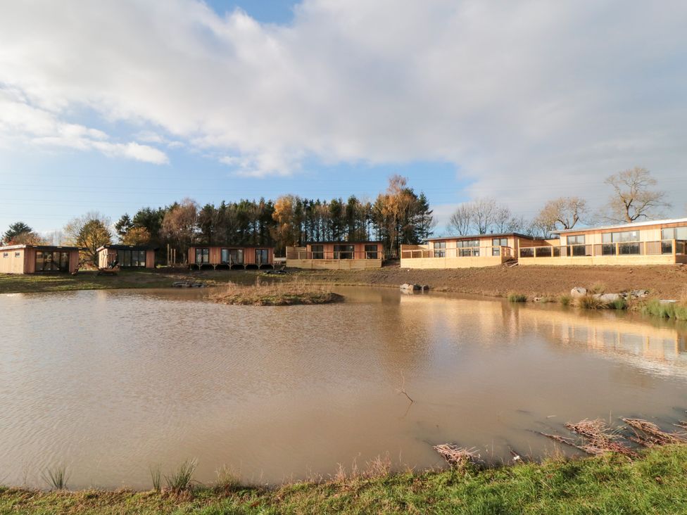 An outdoor area with lodges by a pond at Lodge 8 Stockton-on-Tees