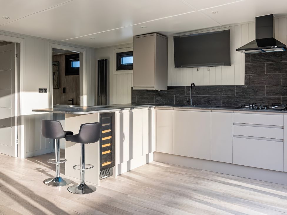 A kitchen with countertop and stools at Mandarin Lodge in Yarm