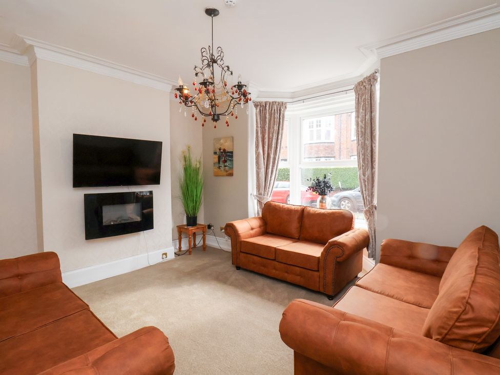 A living room with sofas and a television at Rutland Grange in Filey