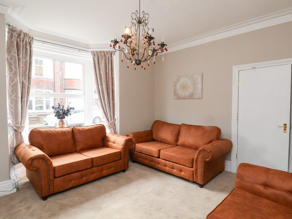 A living room with two sofas and a chandelier at Rutland Grange in Filey