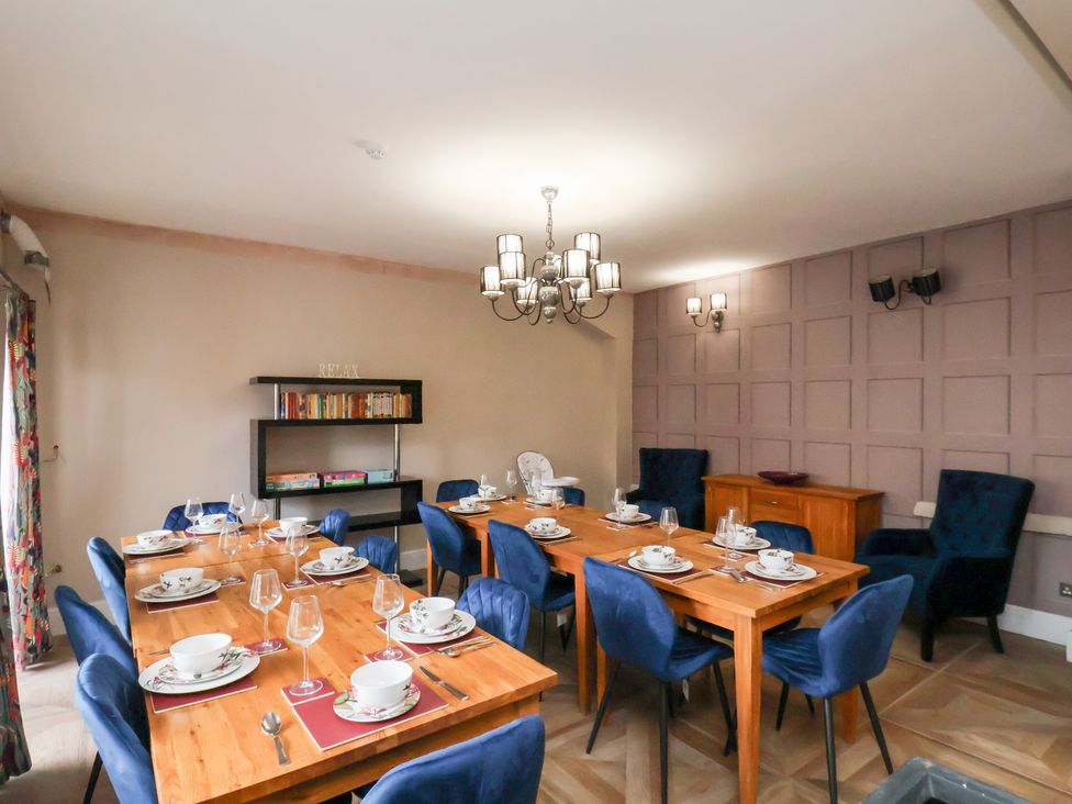 A dining room with a large table set for a meal at Rutland Grange in Filey
