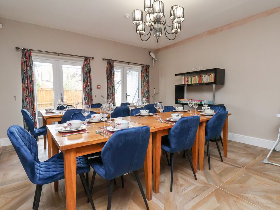A dining room with a large table and chairs at Rutland Grange in Filey