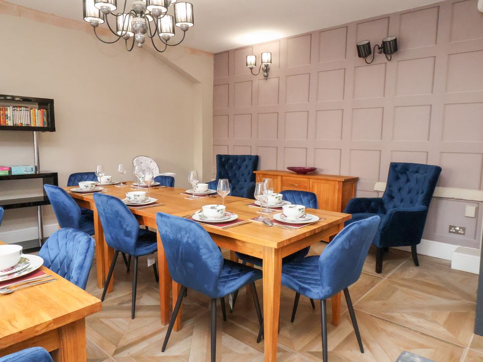A dining room with a wooden table and chairs at Rutland Grange in Filey