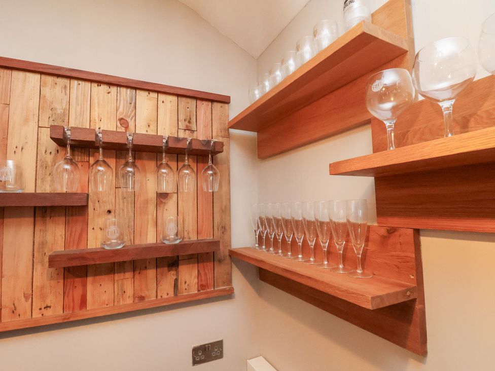 A bar area with shelves displaying wine glasses at Rutland Grange in Filey