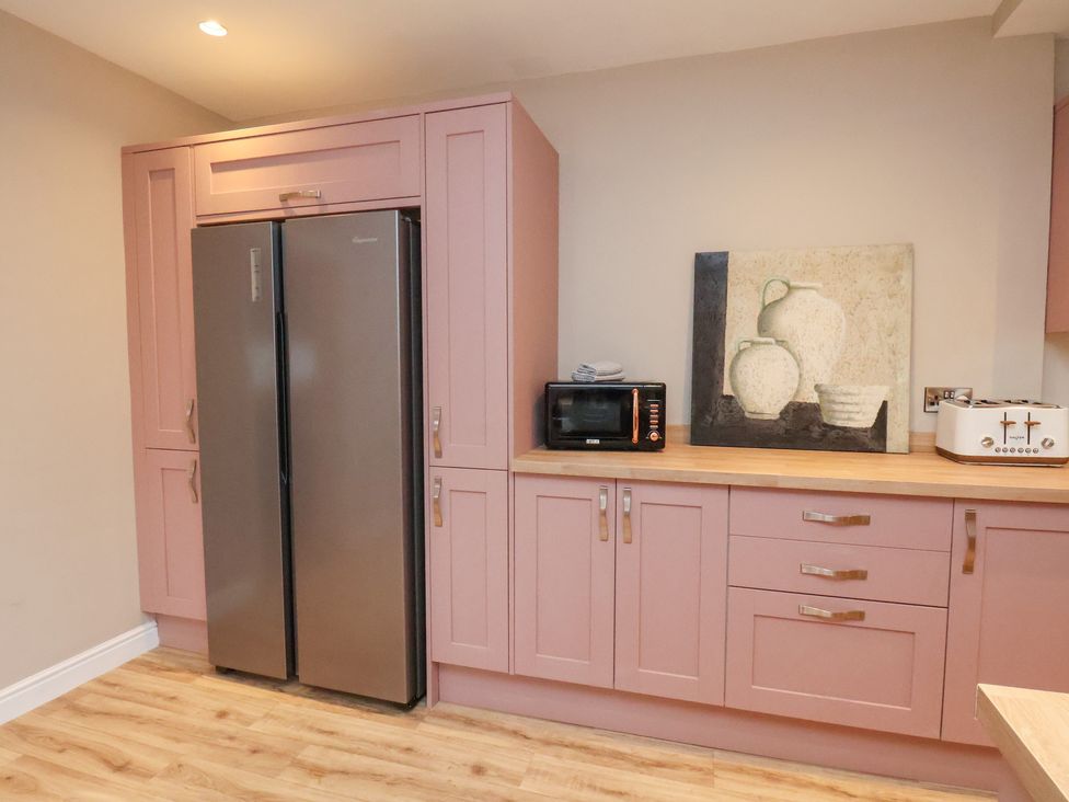 A kitchen with a refrigerator and microwave at Rutland Grange in Filey