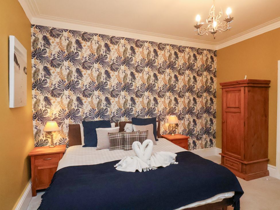 A bedroom with a bed and wardrobe at Rutland Grange in Filey