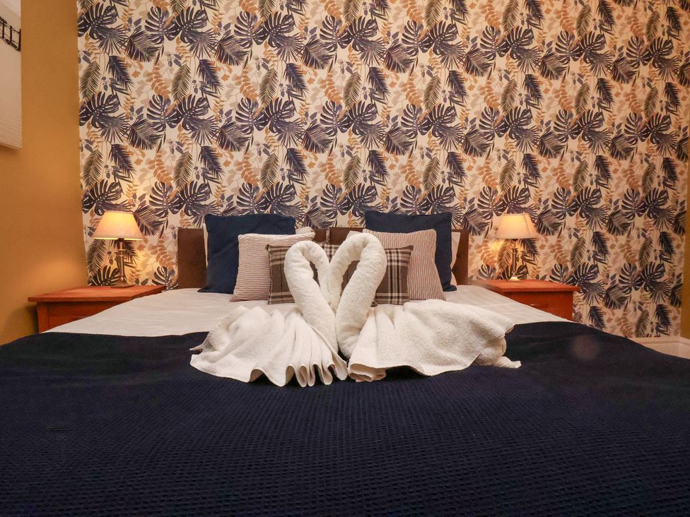 A bedroom with a bed and decorative towels at Rutland Grange in Filey