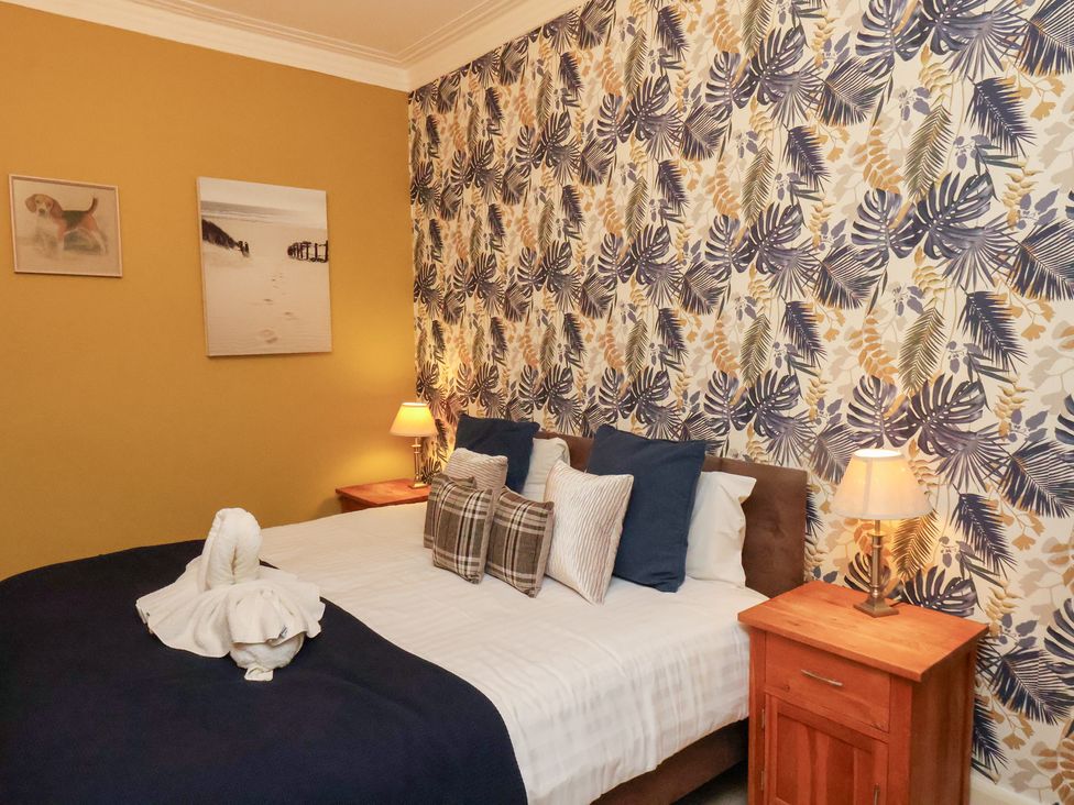 A bedroom with a bed and bedside table at Rutland Grange in Filey