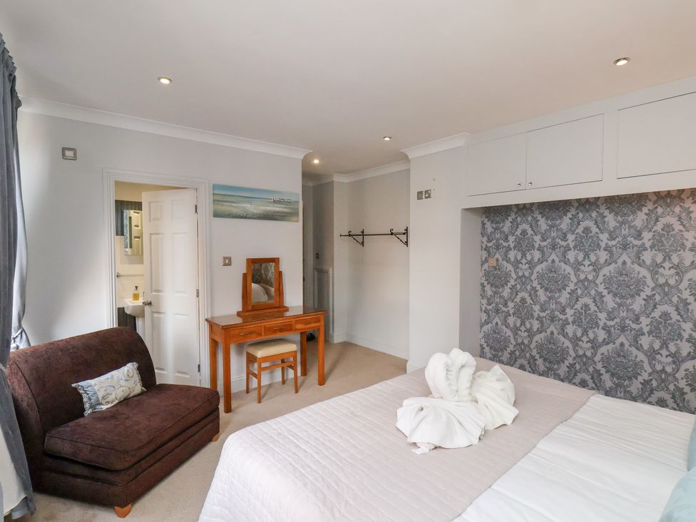 A bedroom with a bed and a seating area at Rutland Grange in Filey