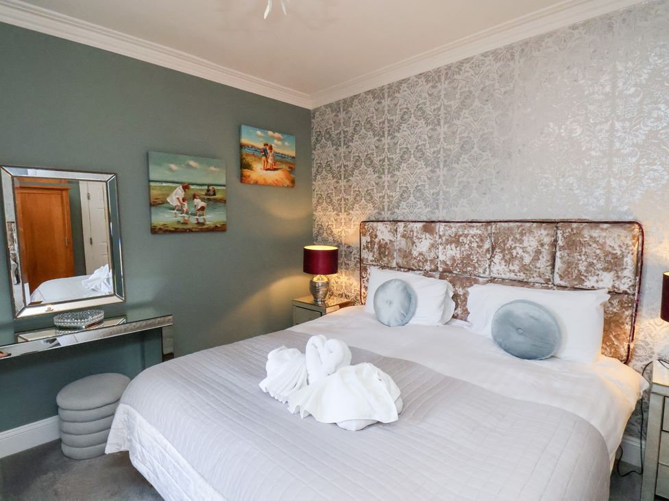 A bedroom with a bed and towels at Rutland Grange in Filey
