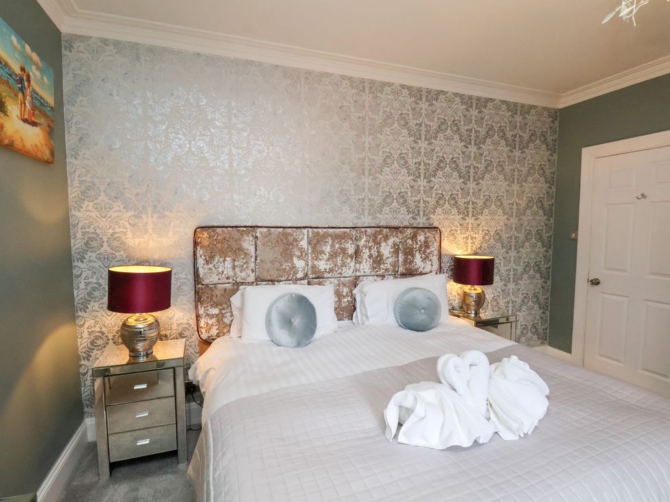 A bedroom with a bed and decorative towels at Rutland Grange in Filey