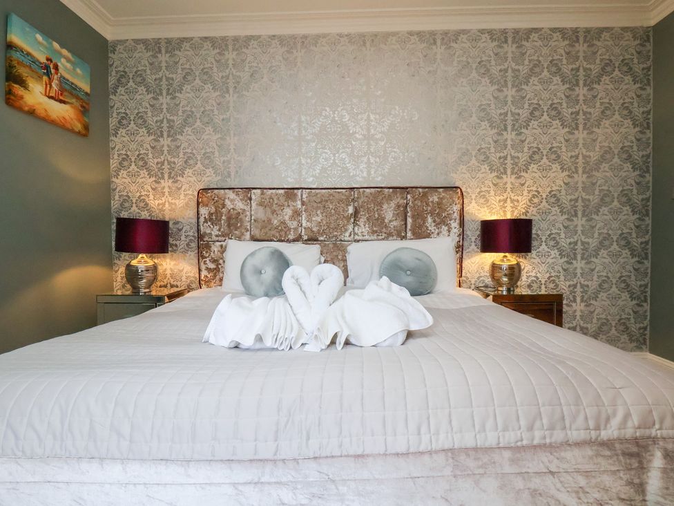 A bedroom with a bed and bedside tables at Rutland Grange in Filey