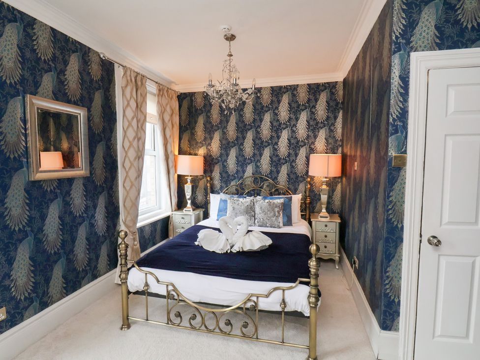 A bedroom with a bed and bedside tables at Rutland Grange in Filey