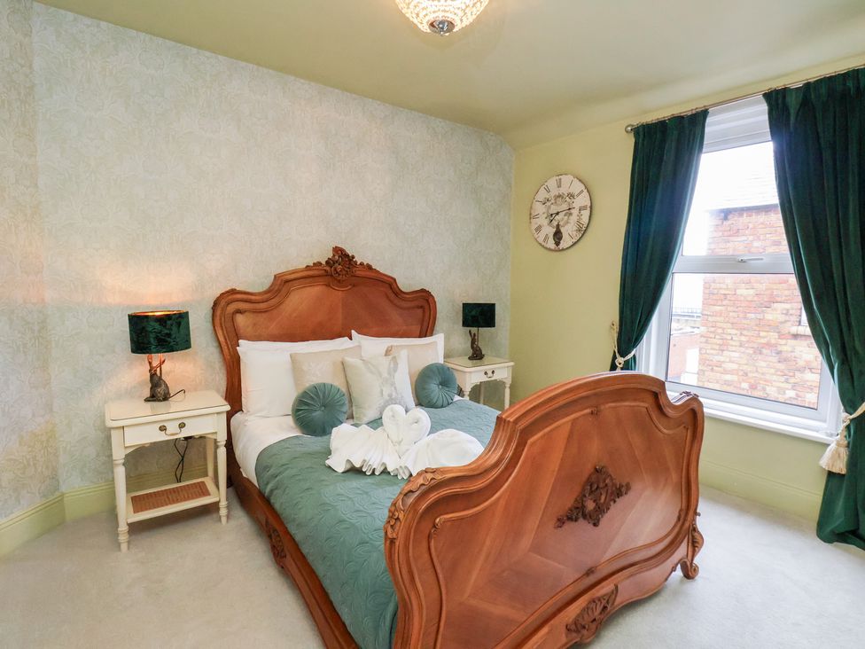 A bedroom with a bed and bedside table at Rutland Grange in Filey