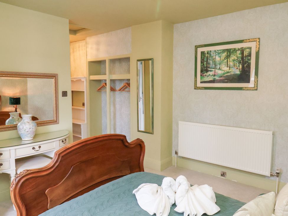 A bedroom with a bed, chest of drawers, and a wardrobe at Rutland Grange in Filey