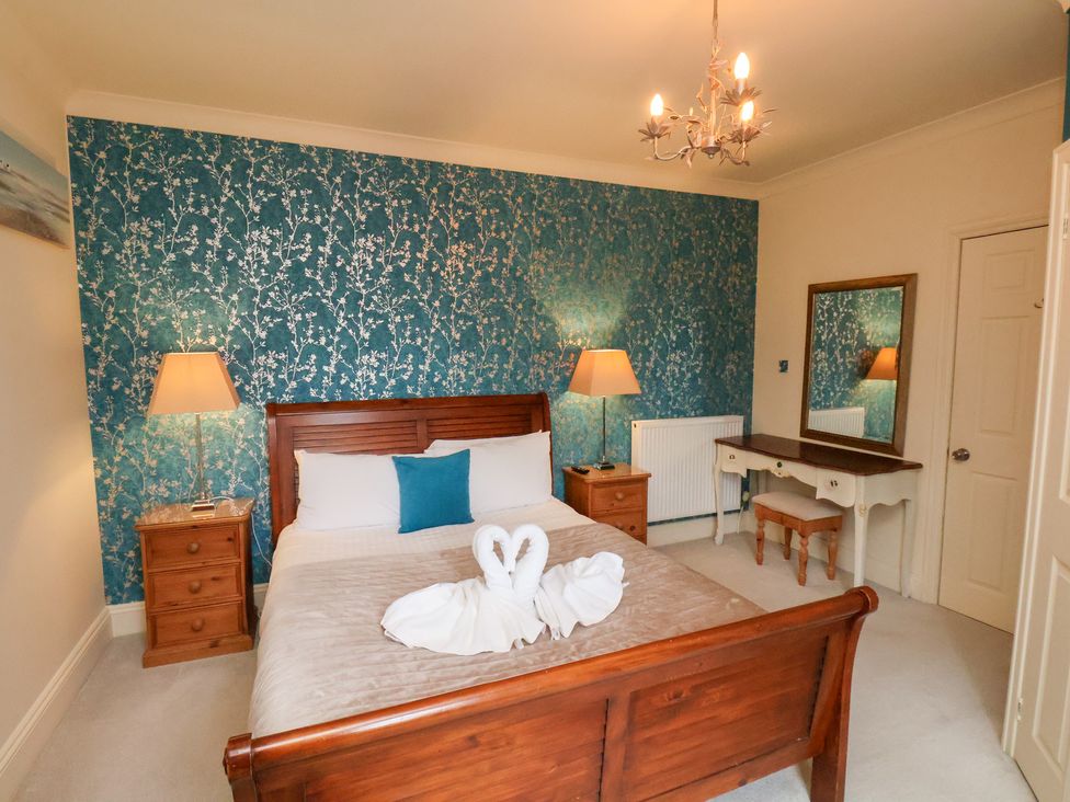 A bedroom with a bed and a desk at Rutland Grange in Filey