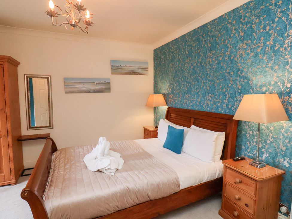 A bedroom with a bed, lamp and wardrobe at Rutland Grange in Filey