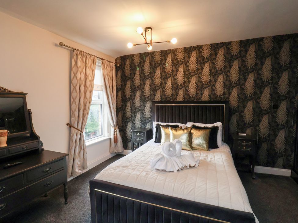 A bedroom with a bed and furniture at Rutland Grange in Filey
