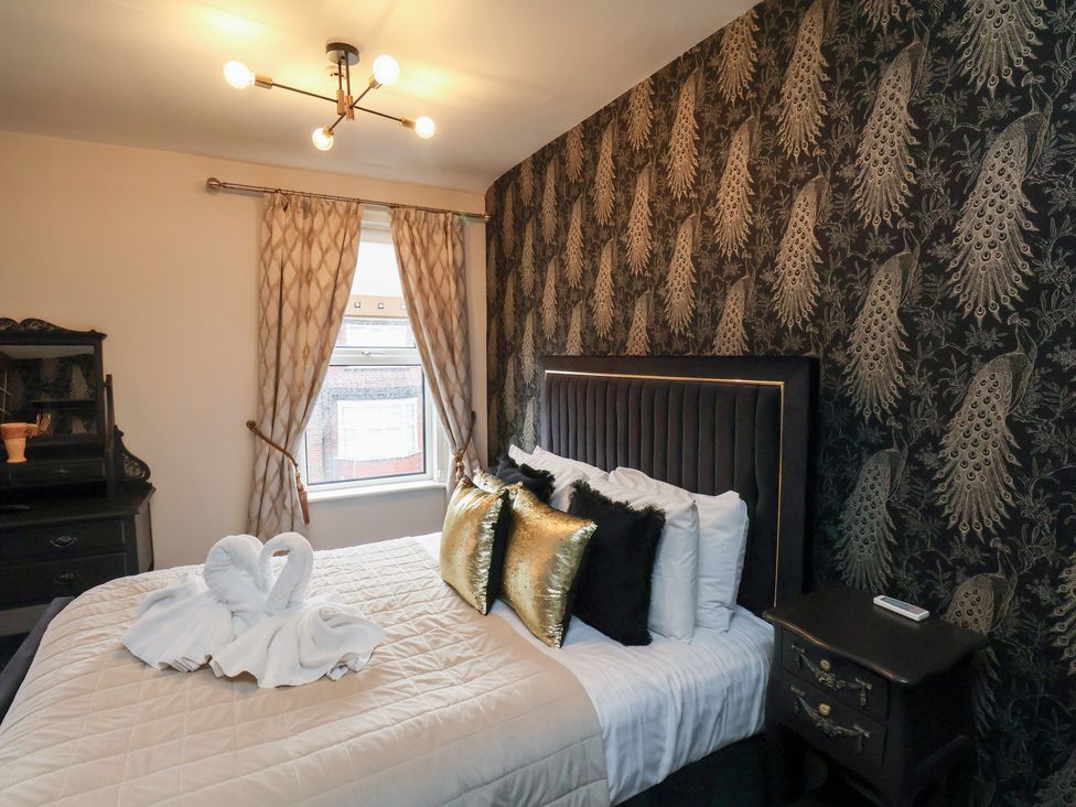 A bedroom with a bed and decorative items at Rutland Grange in Filey