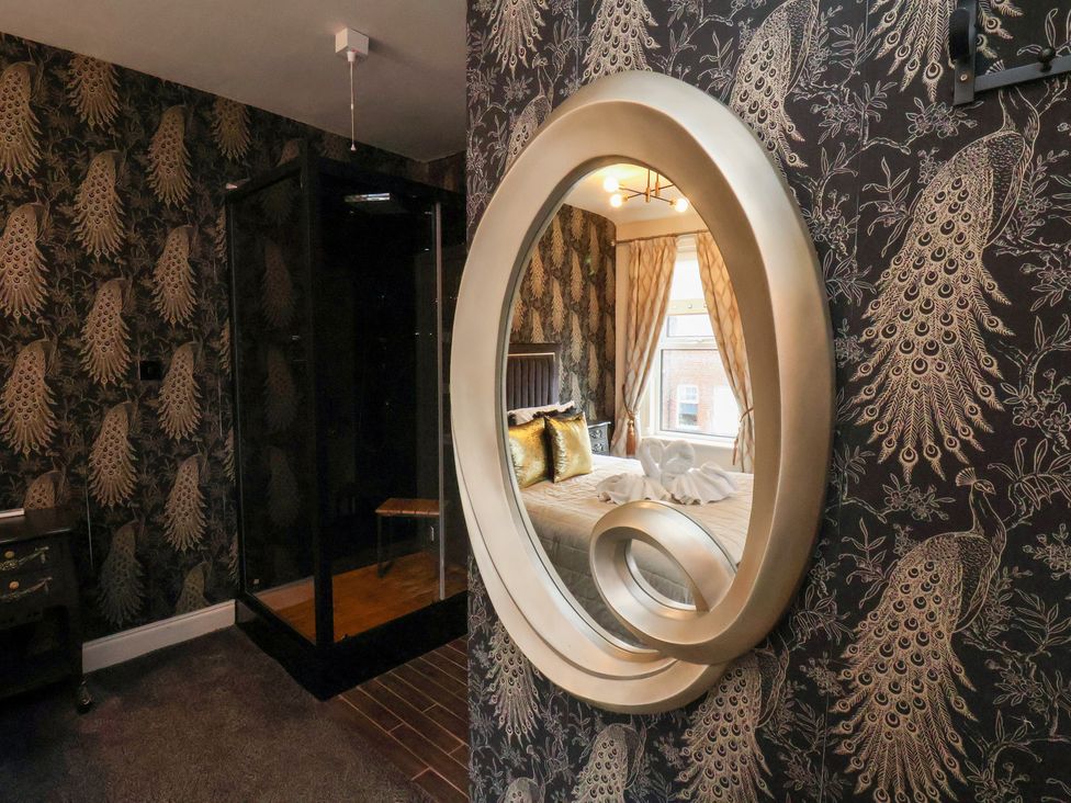A bedroom with a mirror and bed at Rutland Grange Filey