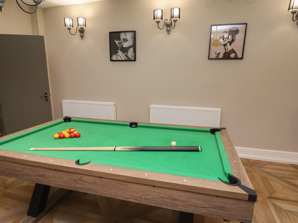 A game room with a pool table and wall art at Rutland Grange in Filey