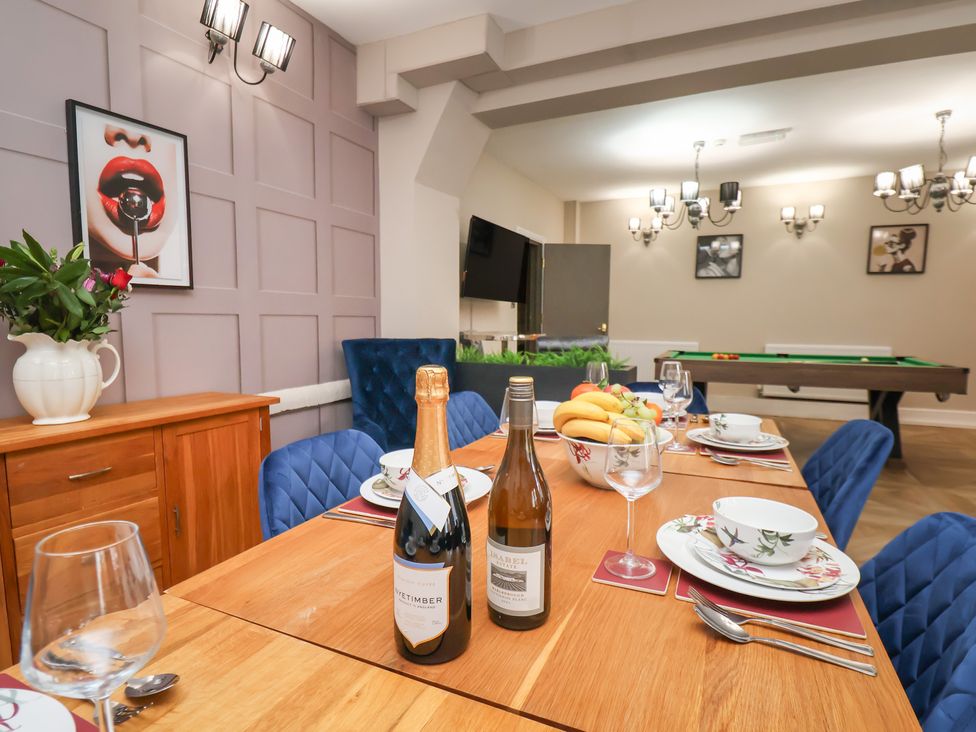 A dining room with a table set for a meal at Rutland Grange in Filey