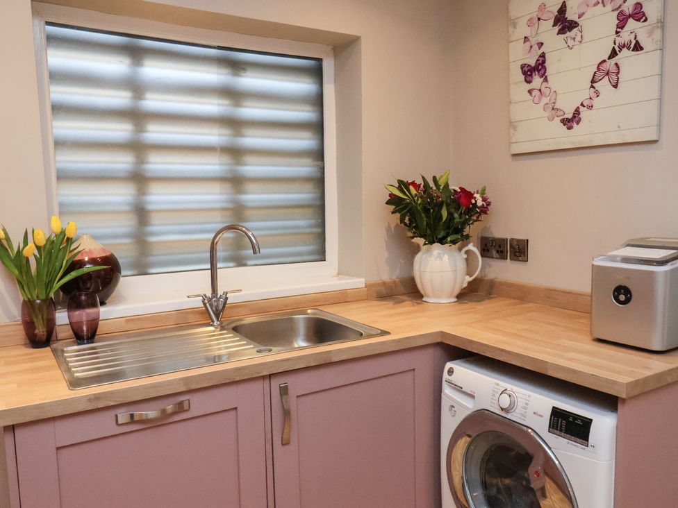 A kitchen with a sink and washing machine at Rutland Grange in Filey