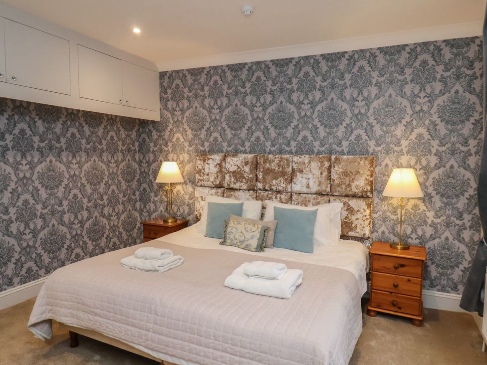 A bedroom with a bed and lamps at Rutland Grange in Filey