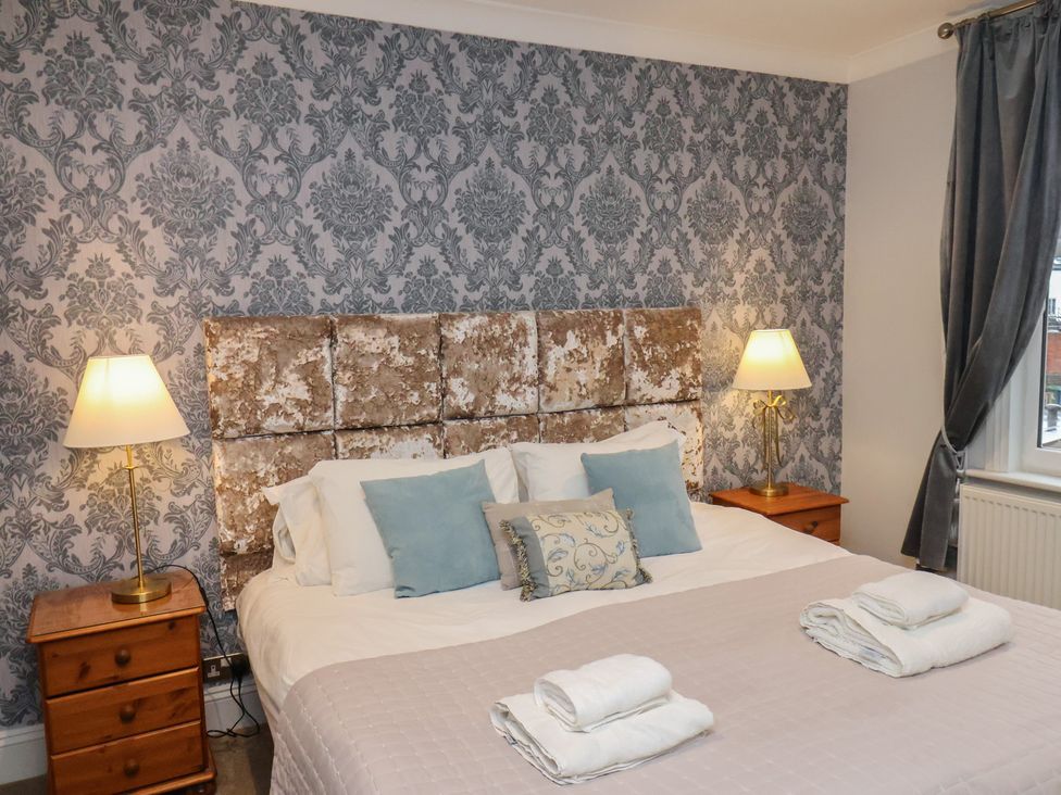 A bedroom with a bed and lamps at Rutland Grange in Filey