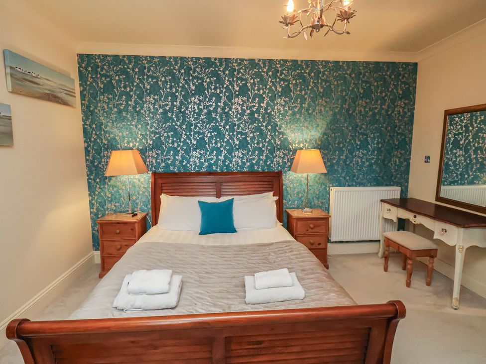 A bedroom with a bed and dressing table at Rutland Grange in Filey