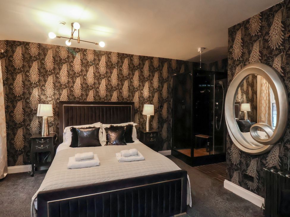 A bedroom with a bed and nightstands at Rutland Grange in Filey