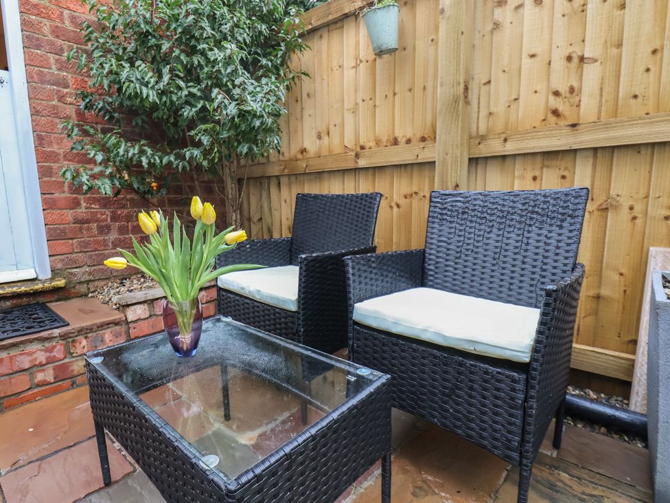 An outdoor patio with two chairs and a table at Rutland Grange in Filey