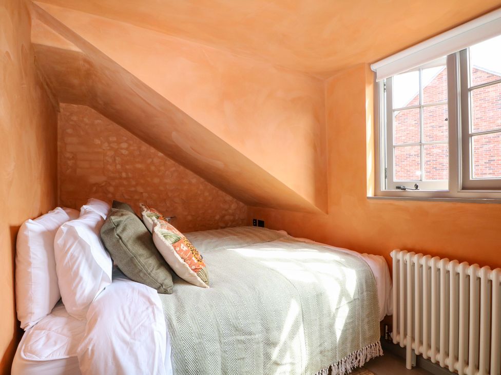 A bedroom with a bed and pillows at Spring Cottage in Arundel, West Sussex