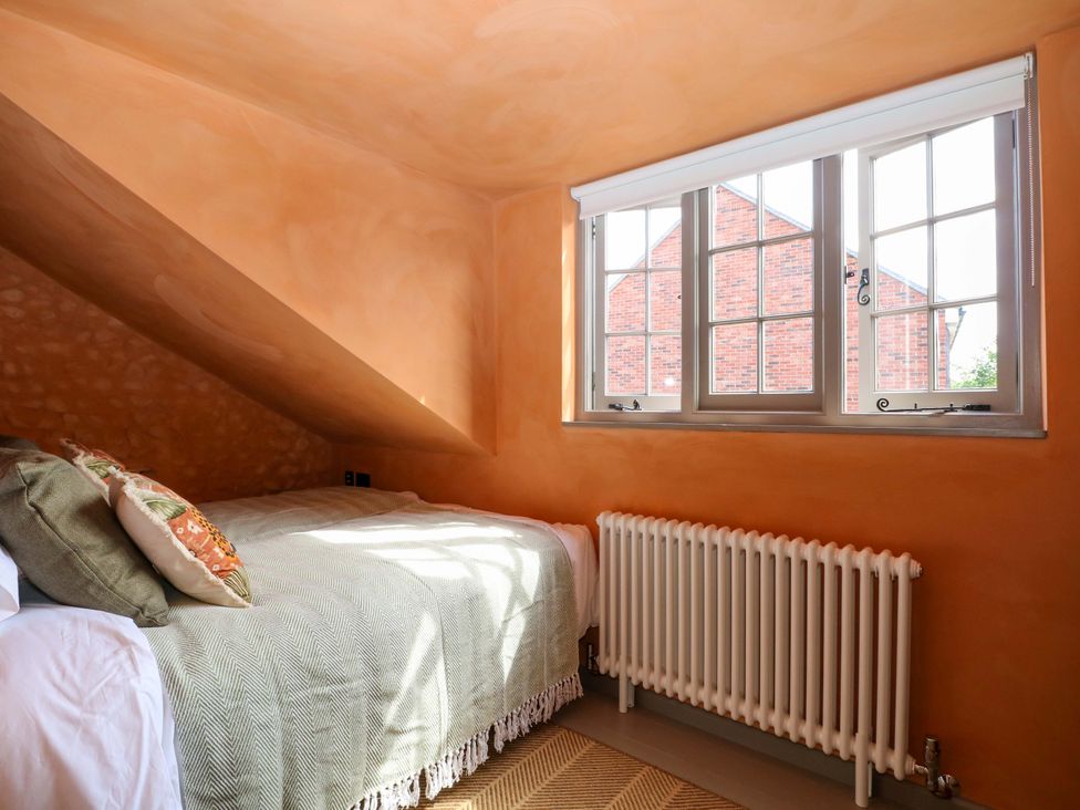 A bedroom with a bed and window at Spring Cottage in Arundel, West Sussex