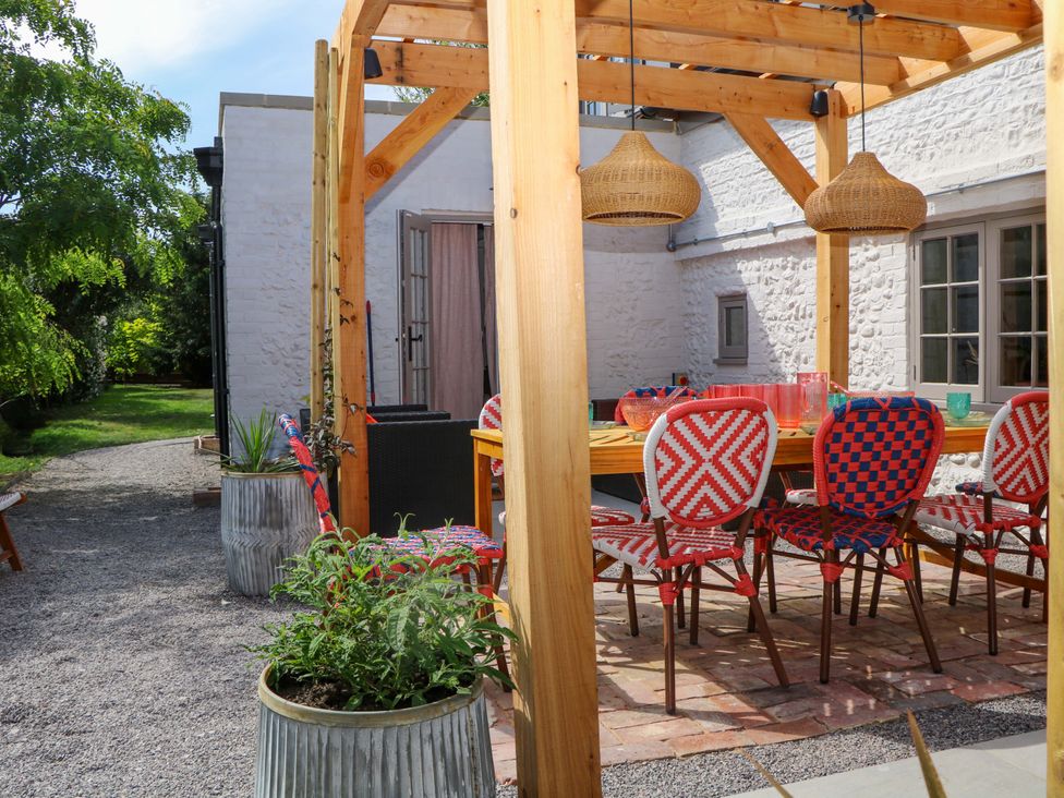 An outdoor dining area with a table and chairs at Spring Cottage in Arundel, West Sussex