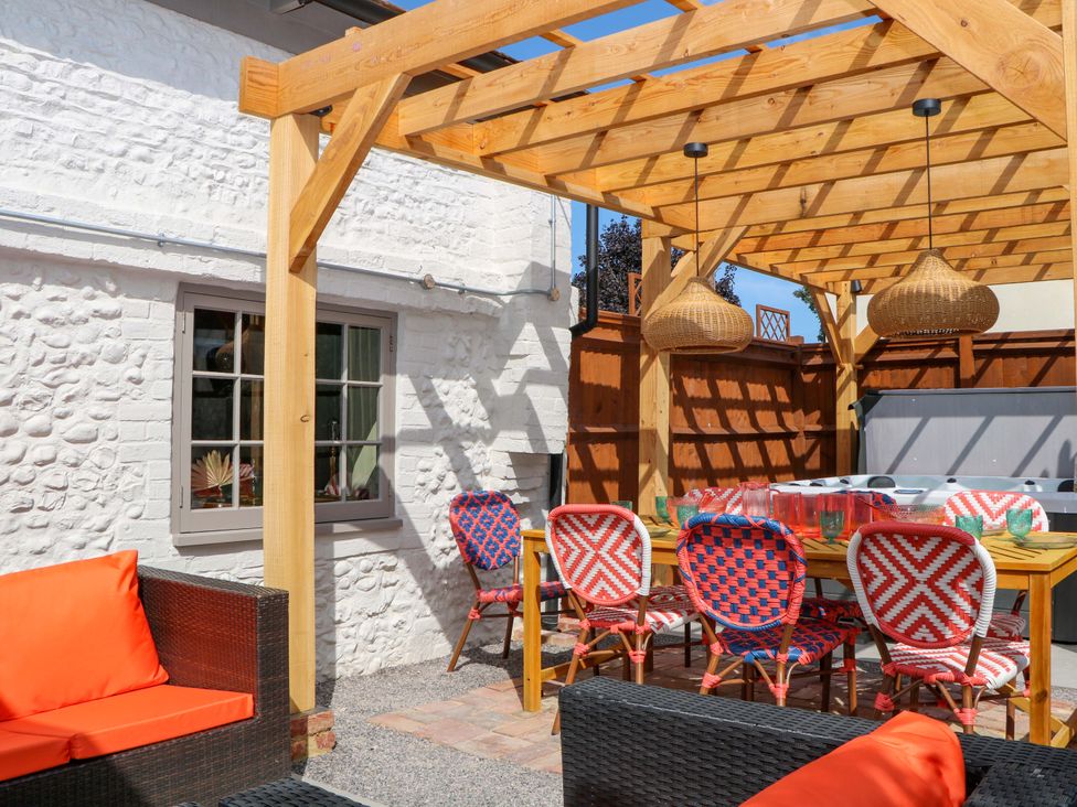 An outdoor dining area with a table and chairs at Spring Cottage in Arundel, West Sussex
