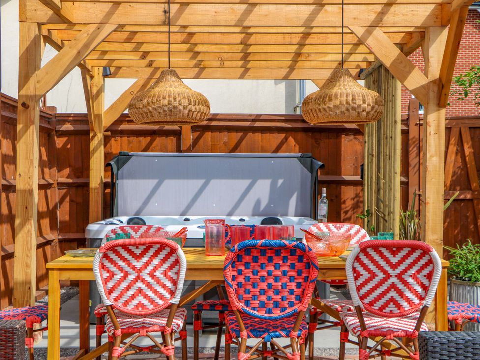 An outdoor dining area with a table and chairs at Spring Cottage in Arundel, West Sussex