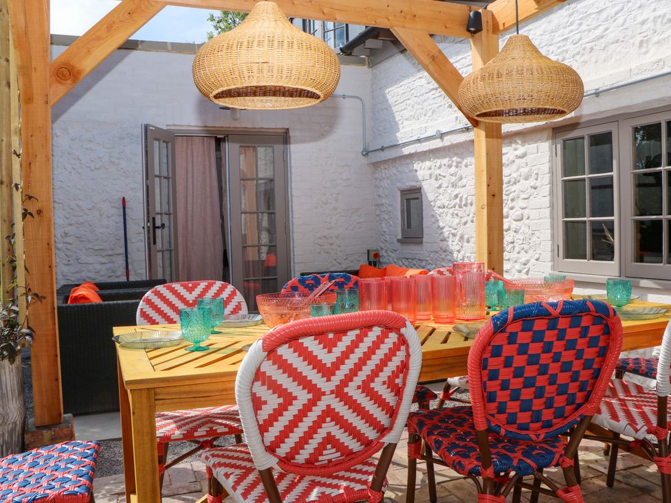 An outdoor dining area with a table and chairs at Spring Cottage in Arundel, West Sussex
