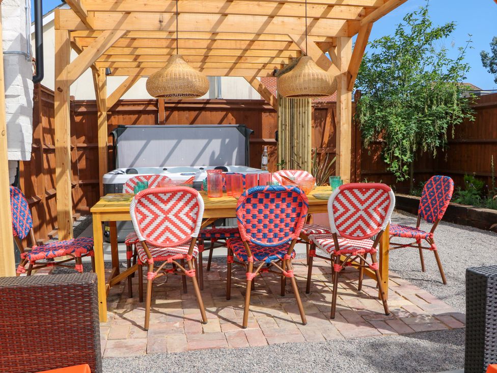 An outdoor dining area with a table and chairs at Spring Cottage in Arundel, West Sussex