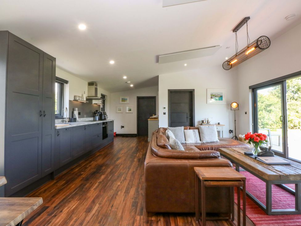 A living room with a sofa and coffee table at Y Cwt in Moelfre