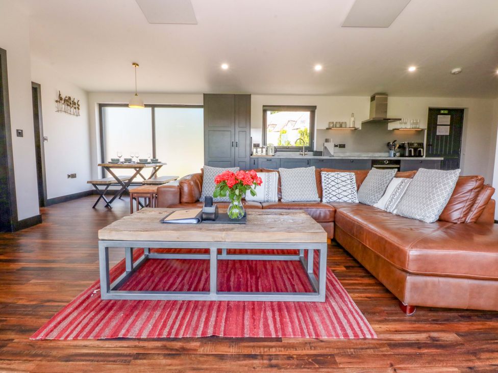 A living room with a sofa and coffee table at Y Cwt in Moelfre