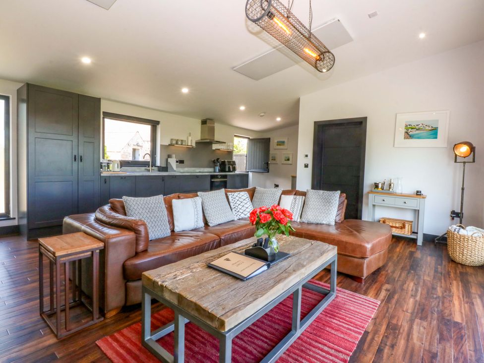 A living room with a sofa and coffee table at Y Cwt in Moelfre