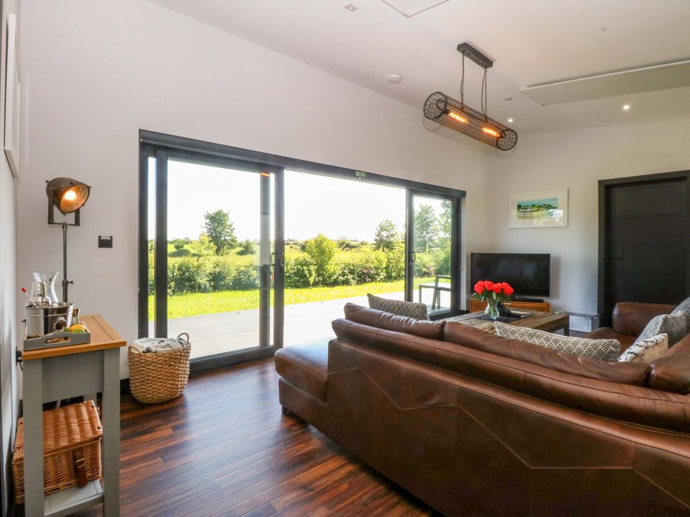 A living room with a sofa and a coffee table at Y Cwt in Moelfre