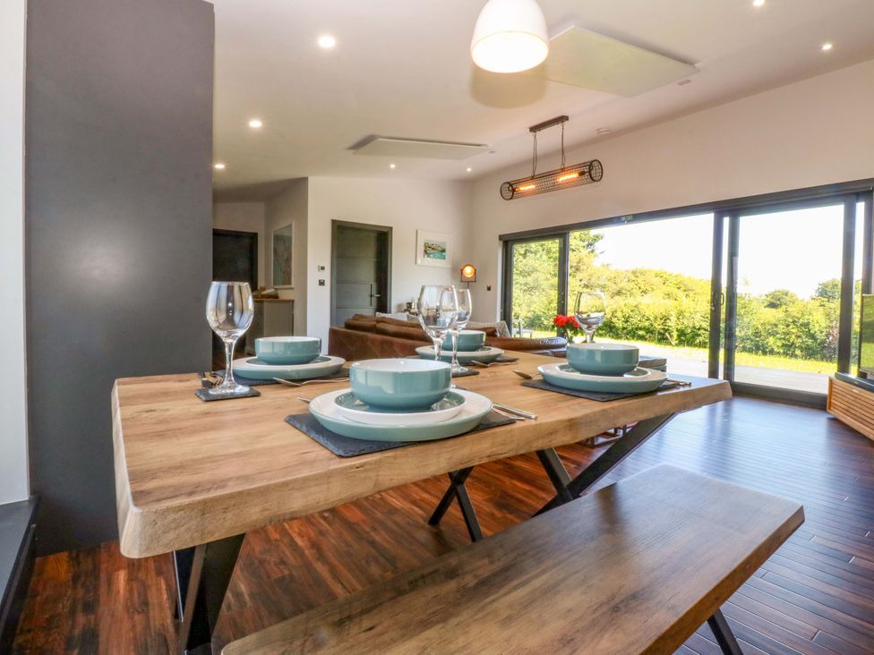 A dining room with a table set for a meal at Y Cwt in Moelfre